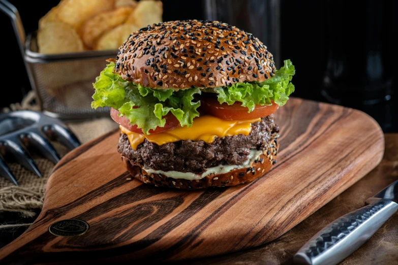 hamburger on  board with knife and potato chips