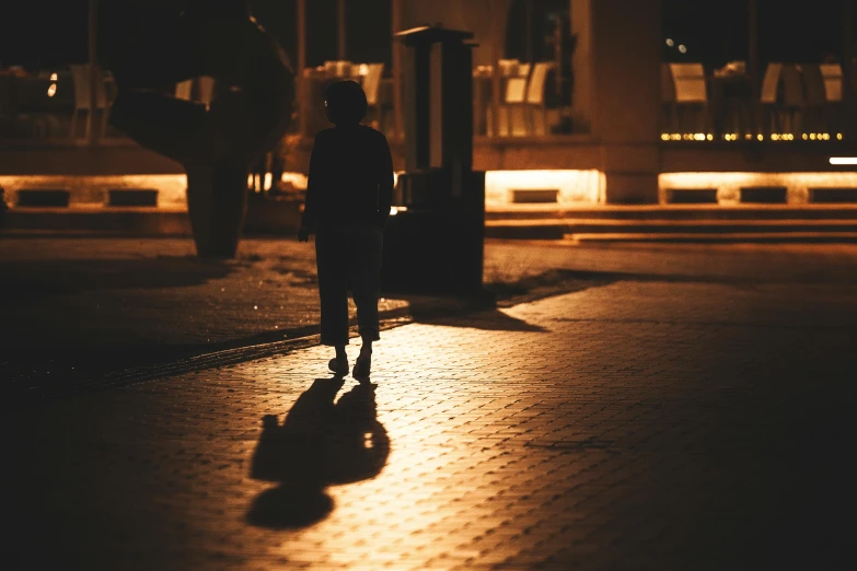 a woman is silhouetted walking down a street