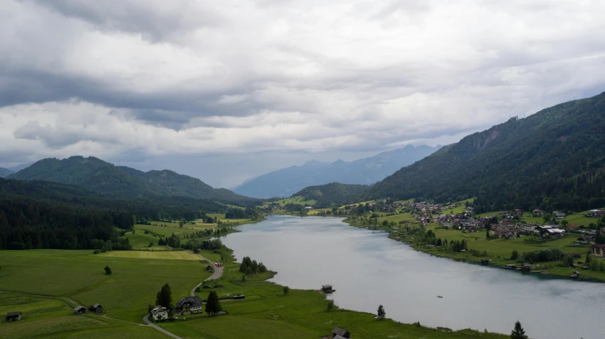 a river surrounded by mountains and houses on it