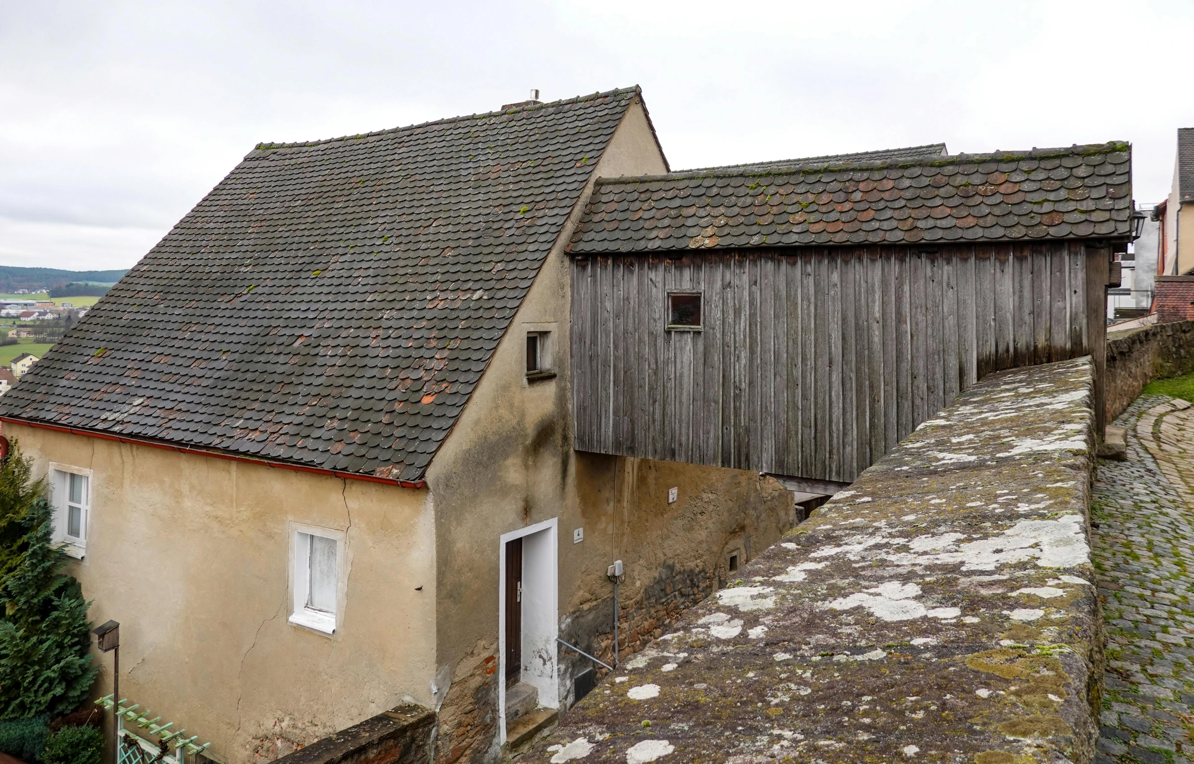 two buildings one with a large window and the other with a roof