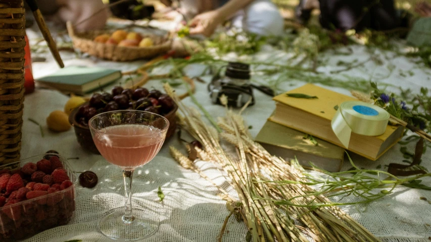 fruit, flowers and wine are sitting on a table