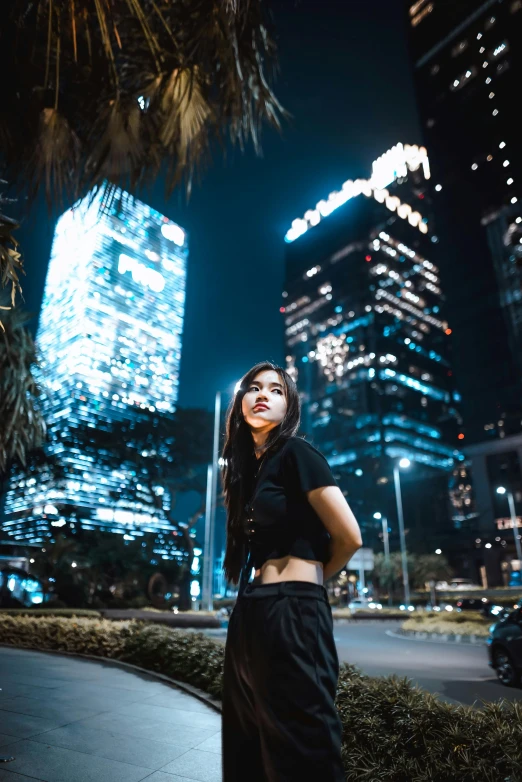 a woman standing on the street in front of a city