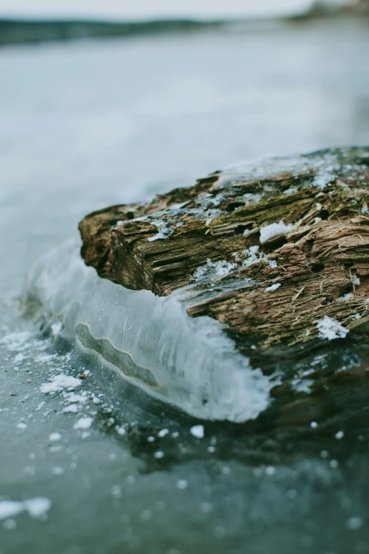 a piece of ice sits on the ice next to the water