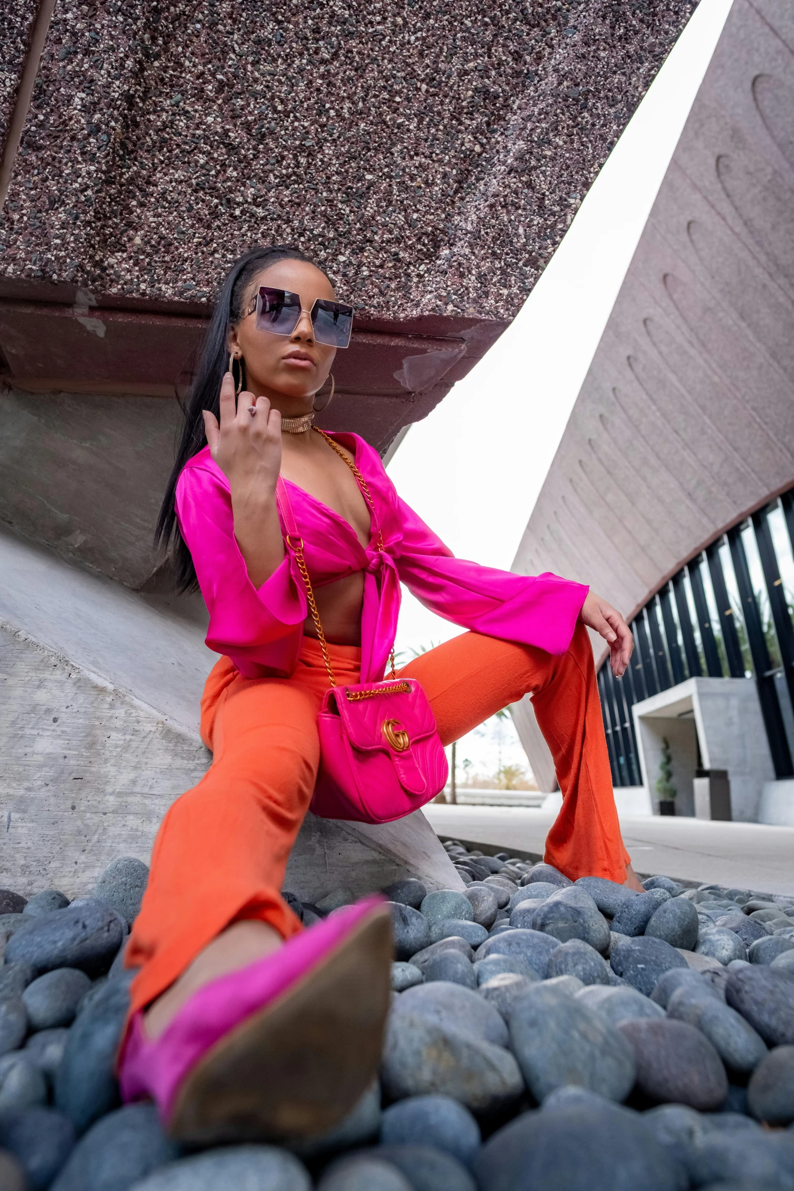 a woman wearing orange pants and a pink blouse