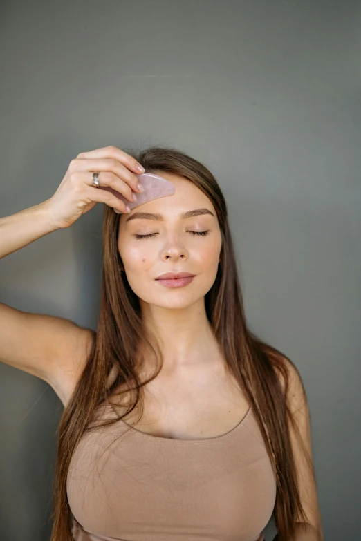 the girl is touching her face with her hand