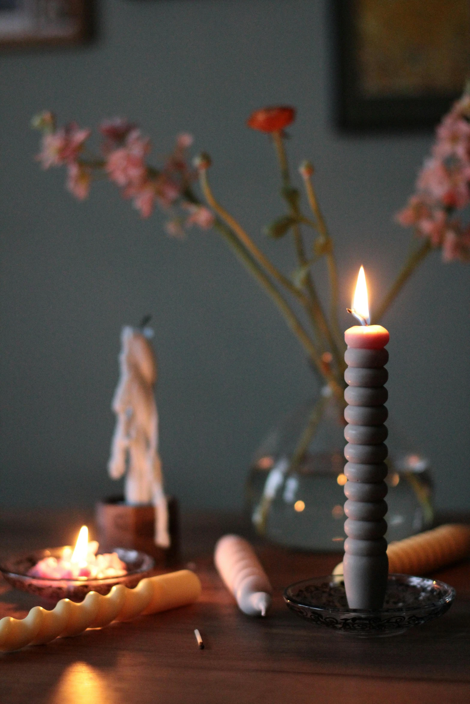 candles sit on a table near small flowers