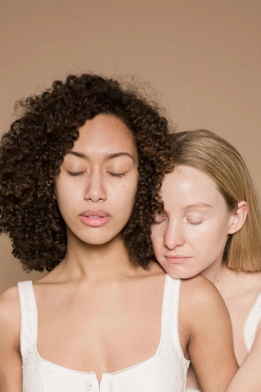 two women who are both wearing makeup and one with curly hair