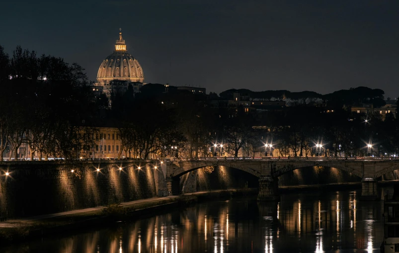 a lighted up city at night next to a bridge