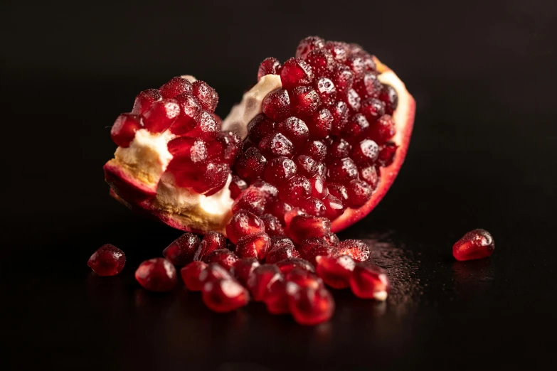 a cut up half eaten fruit on a black surface