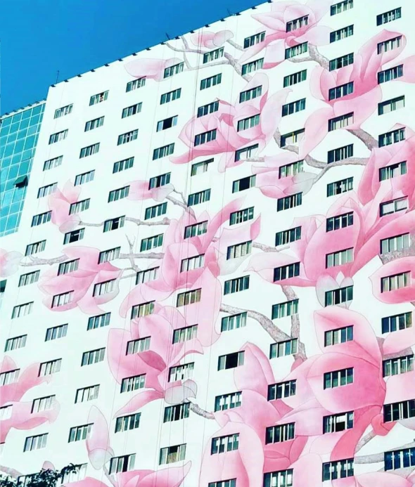 a tall building with pink flowers painted on the side