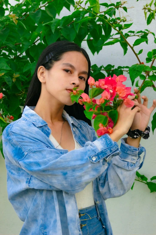 a girl holds a flower arrangement in front of a building