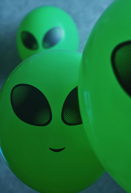 the green balls have an alien face on them