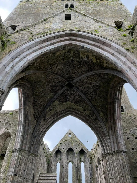 a large arched hallway with stone pillars and a roof