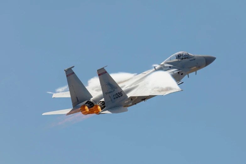 a fighter jet flying through a clear blue sky