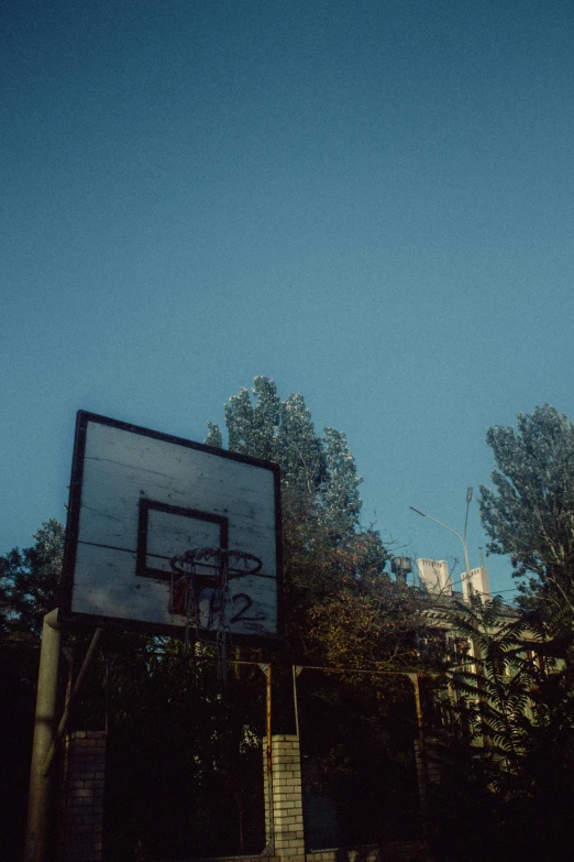 basketball goal and trees against blue sky and clouds