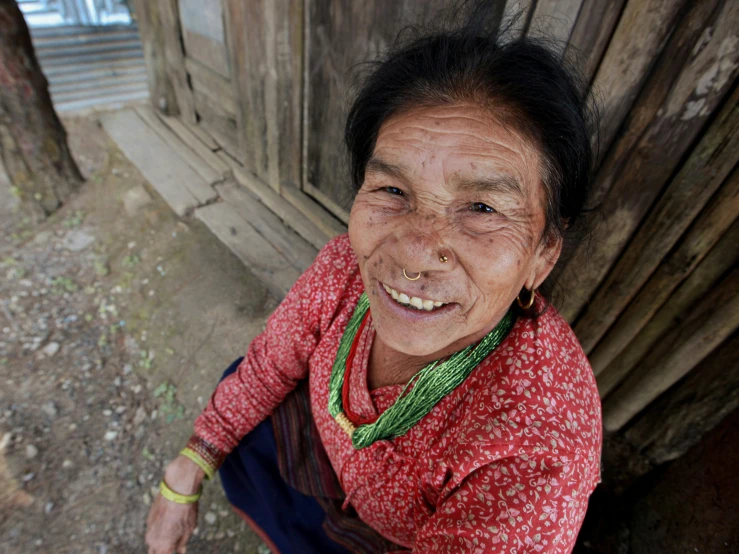 an old woman in red and green sweater smiling