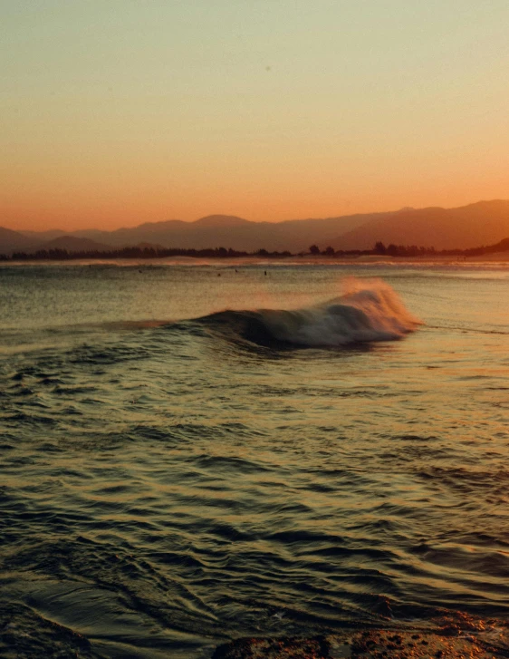 the ocean is reflecting the sun and hills