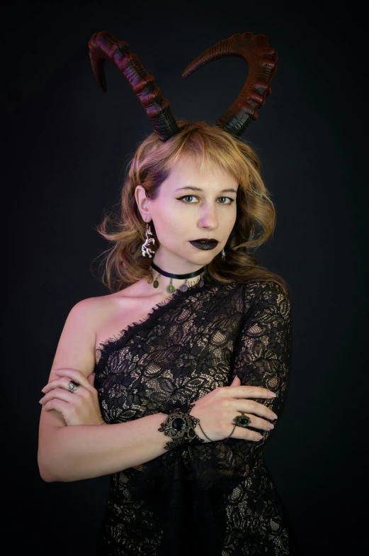 a woman poses with horns and lace dress