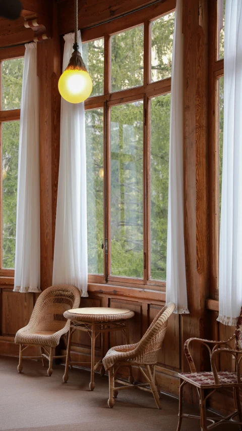 a room with large windows filled with furniture and a chandelier