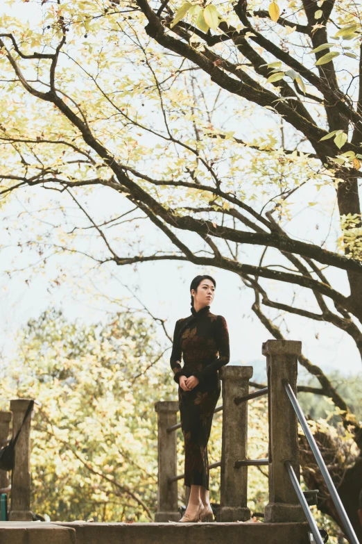 a woman in black standing on a bridge