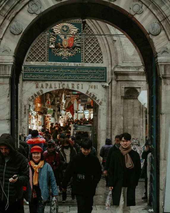 a large group of people walk by an entrance to a mosque