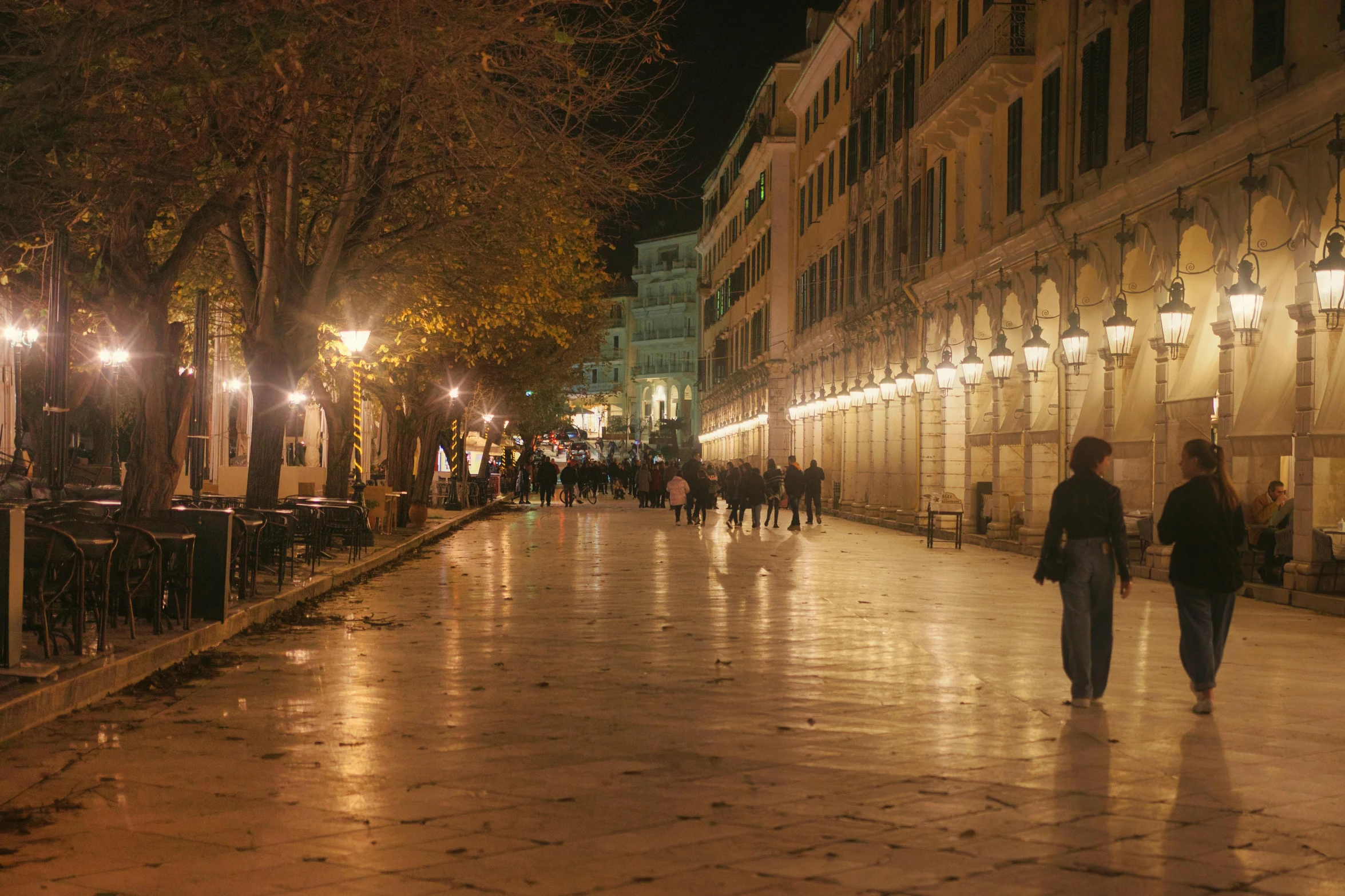 people walking down the street on a rainy night