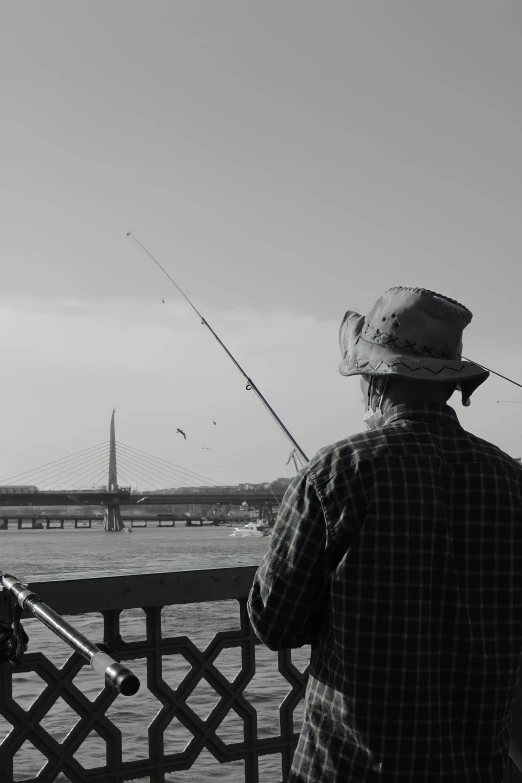 the man is fishing off a pier