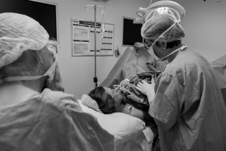 doctors in scrubs perform an operation on an infant