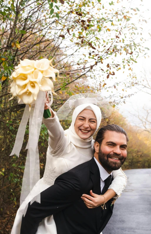 two people smiling at the camera with a woman wearing a head piece on her back