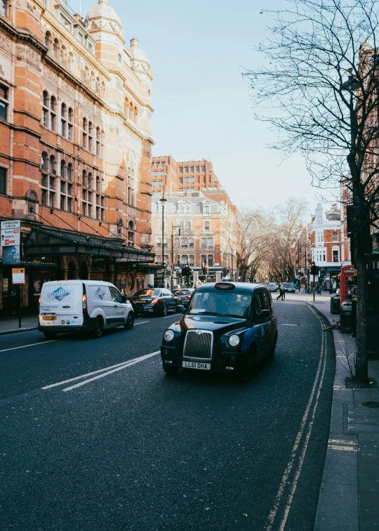 a car traveling down a city street with many tall buildings on either side of the road