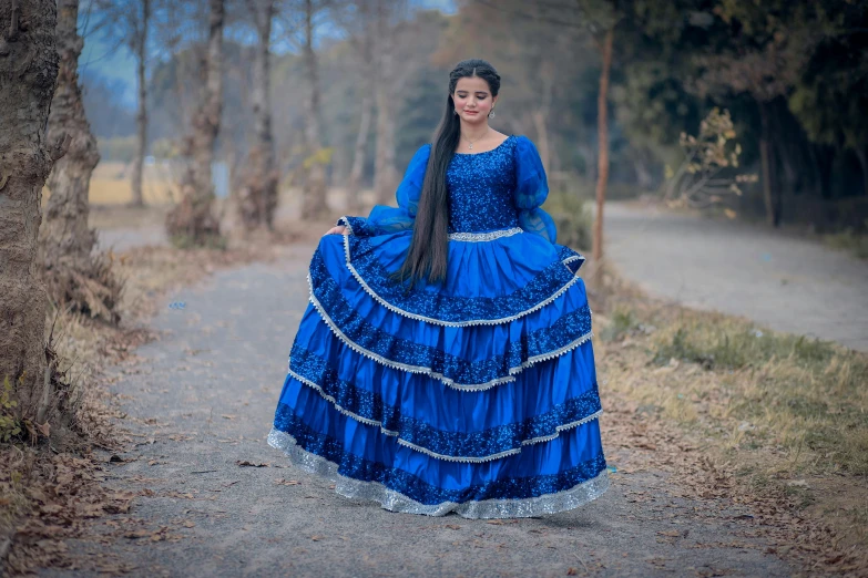 a woman in a long blue dress posing for a picture