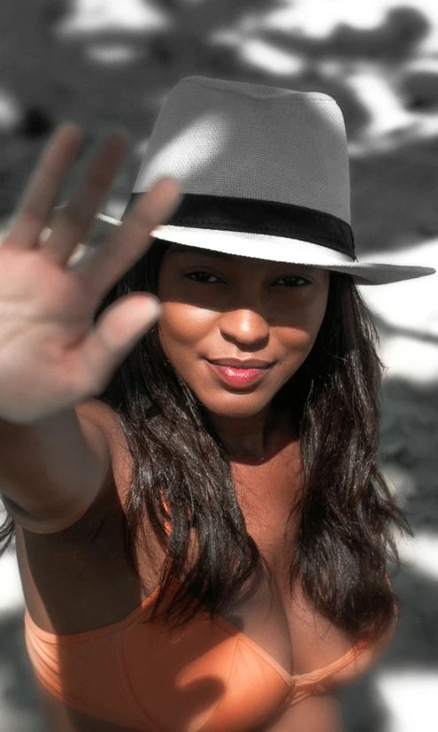 a lady in a fedora with a hand up