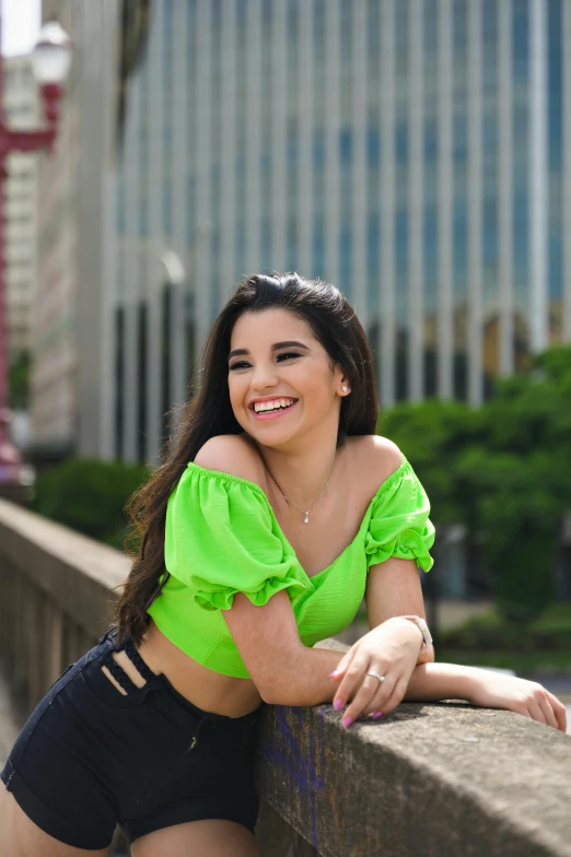 a beautiful woman in a green shirt posing for the camera