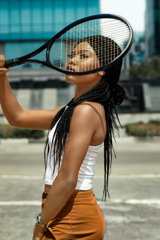 a woman holding a tennis racket and posing in a white top