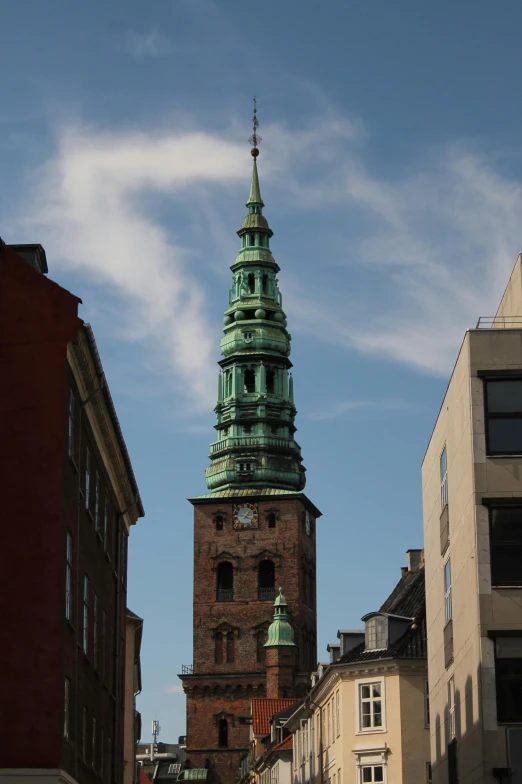 a large tall tower with a green steeple on the top