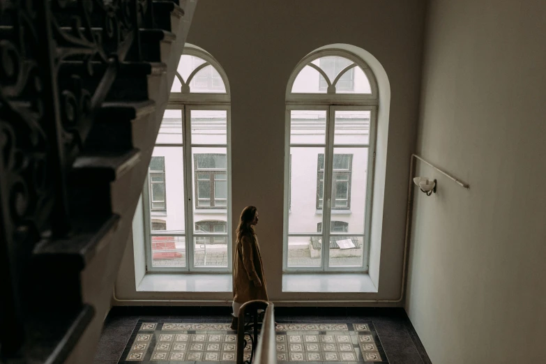 a woman walks down the stairs in a house