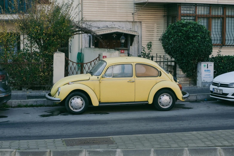 an old yellow car is parked on the street