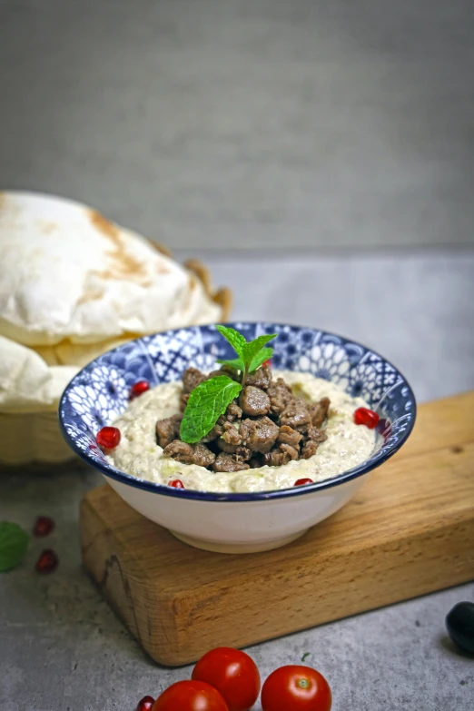 a bowl full of food is on a  board