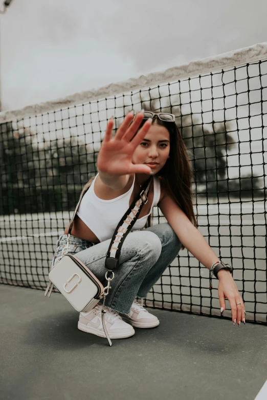 woman is sitting on the ground waving out her hands