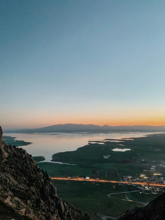 the view of a lake in the distance at dusk