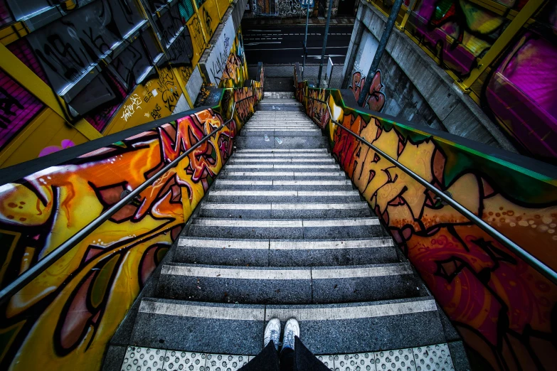 a man walking up the stairs covered in graffiti