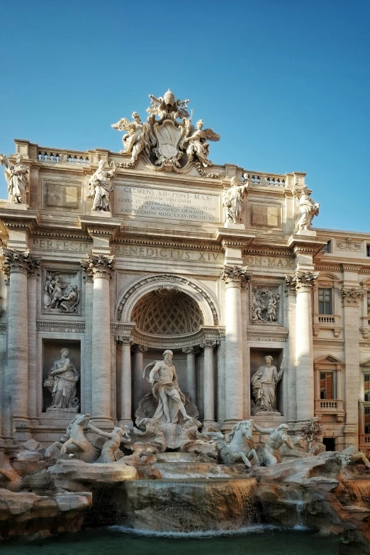 a large building with an arch and fountain outside