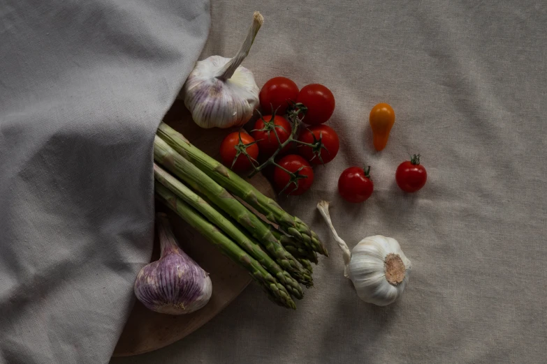 a few vegetables sit on a gray fabric