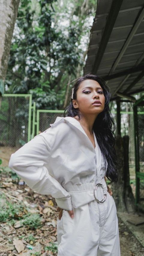 a woman posing for a po wearing a white jumpsuit