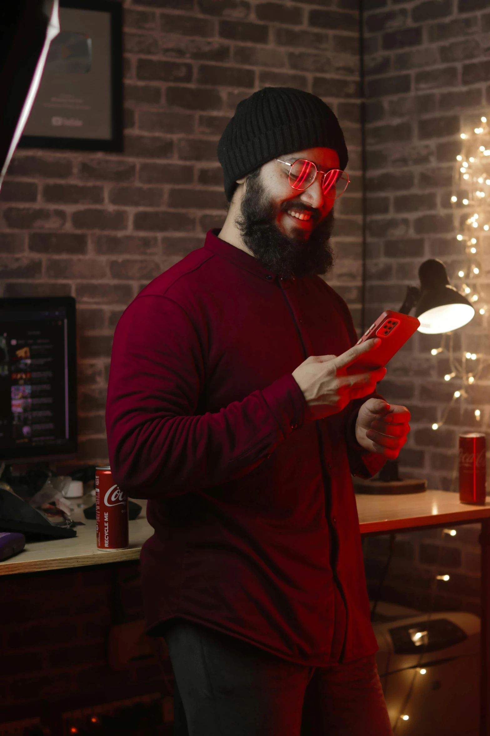 bearded man standing in front of a mirror, holding a lit candle and wearing a hat