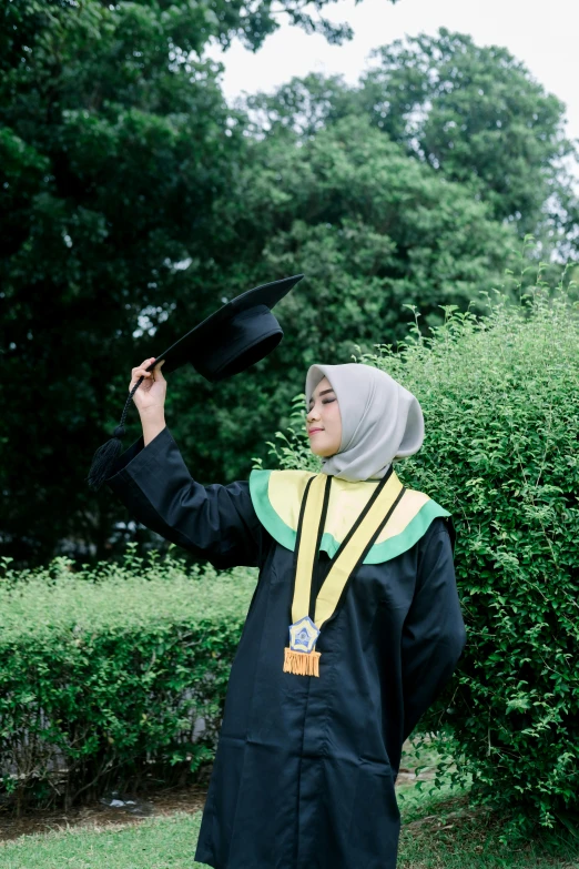 a young man in a mortaron holding a graduate's cap