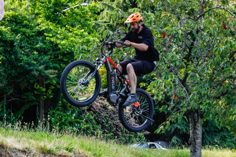 a man on a bike in mid - air with trees in the background