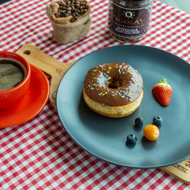 a doughnut on a plate next to a cup of coffee