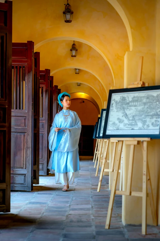 a woman in a dress walking down a stone pathway