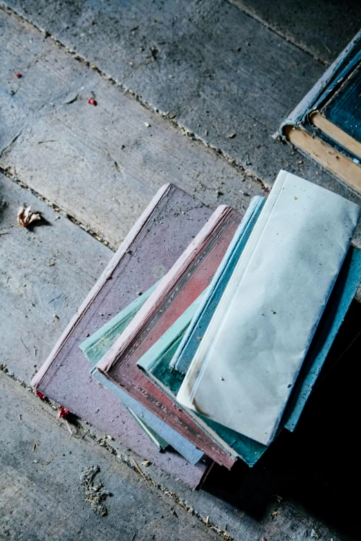 multiple stacks of discarded, un - folded papers sit on the sidewalk